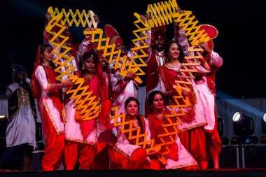 BİKANER, RAJASTHAN / INDIA - HAZİRAN 2019: Punjab 'lı Erkek ve Kadın Bhangra sanatçıları grubu Bikaner Camel festivali sırasında Bhangra dansı yapıyor