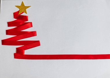 Kırmızı Noel ağacı, kırmızı kurdele, altın yıldız ve beyaz arka planda Noel çanları..
