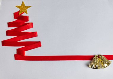 Kırmızı Noel ağacı, kırmızı kurdele, altın yıldız ve beyaz arka planda Noel çanları..