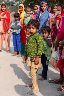 NOIDA, UTTAR PRADESH, INDIA - NOVEMBER 2020: Hindistan 'ın köy veya gecekondu mahallelerinden gelen genç çocukların portresi, kış boyunca okulda duruyor ve salgın sırasında sivil toplum örgütü tarafından dağıtılıyor. Zor zamanlarda topluma geri vermek.
