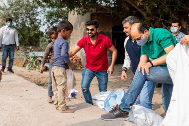NOIDA, UTTAR PRADESH, INDIA - Kasım 2020: Hindistan 'daki sivil toplum örgütü gençlerinden oluşan bir grup, salgın sırasında yoksul çocuklara ve gecekondu halkına yiyecek dağıtıyor. Zor zamanlarda topluma geri vermek.