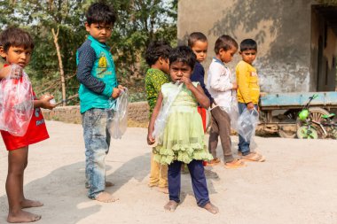 NOIDA, UTTAR PRADESH, INDIA - NOVEMBER 2020: Hindistan 'da Corona salgını sırasında gönüllülerin dağıttığı yiyecekleri toplamak için kenar mahalle veya köy bölgesinden gelen genç çocuklar veya öğrenciler. Topluma geri vermek..