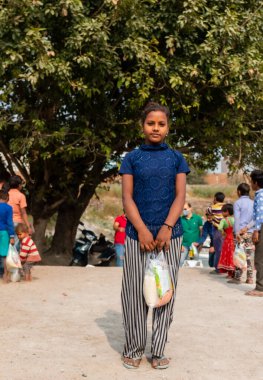 NOIDA, UTTAR PRADESH, INDIA - NOVEMBER 2020: Hindistan 'ın köy veya gecekondu mahallelerinden gelen genç çocukların portresi, kış boyunca okulda duruyor ve salgın sırasında sivil toplum örgütü tarafından dağıtılıyor. Zor zamanlarda topluma geri vermek.