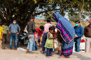 NOIDA, UTTAR PRADESH, INDIA - NOVEMBER 2020: Hindistan 'ın köy veya gecekondu mahallelerinden gelen genç çocukların portresi, kış boyunca okulda duruyor ve salgın sırasında sivil toplum örgütü tarafından dağıtılıyor. Zor zamanlarda topluma geri vermek.