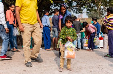 NOIDA, UTTAR PRADESH, INDIA - NOVEMBER 2020: Hindistan 'ın köy veya gecekondu mahallelerinden gelen genç çocukların portresi, kış boyunca okulda duruyor ve salgın sırasında sivil toplum örgütü tarafından dağıtılıyor. Zor zamanlarda topluma geri vermek.