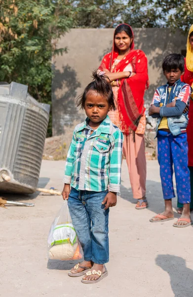 NOIDA, UTTAR PRADESH, INDIA - NOVEMBER 2020: Hindistan 'ın köy veya gecekondu mahallelerinden gelen genç çocukların portresi, kış boyunca okulda duruyor ve salgın sırasında sivil toplum örgütü tarafından dağıtılıyor. Zor zamanlarda topluma geri vermek.