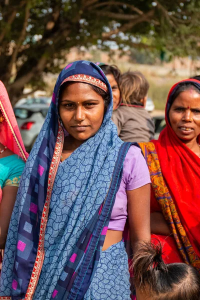NOIDA, UTTAR PRADESH, Hindistan - Kasım 2020: Evlerinin önünde dikilen renkli elbiseli yerli kadınların portresi.