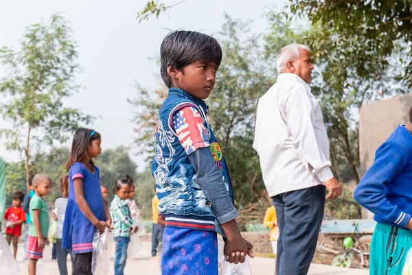 NOIDA, UTTAR PRADESH, INDIA - NOVEMBER 2020: Hindistan 'da Corona salgını sırasında gönüllülerin dağıttığı yiyecekleri toplamak için kenar mahalle veya köy bölgesinden gelen genç çocuklar veya öğrenciler. Topluma geri vermek..