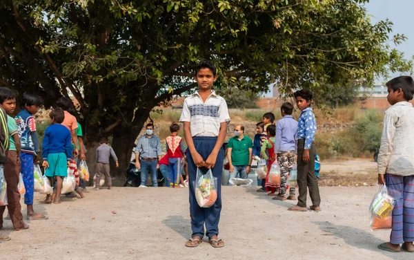 NOIDA, UTTAR PRADESH, INDIA - NOVEMBER 2020: Hindistan 'ın köy veya gecekondu mahallelerinden gelen genç çocukların portresi, kış boyunca okulda duruyor ve salgın sırasında sivil toplum örgütü tarafından dağıtılıyor. Zor zamanlarda topluma geri vermek.