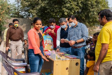 NOIDA, UTTAR PRADESH, INDIA - Kasım 2020: Hindistan 'daki sivil toplum örgütü gençlerinden oluşan bir grup, salgın sırasında yoksul çocuklara ve gecekondu halkına yiyecek dağıtıyor. Zor zamanlarda topluma geri vermek.