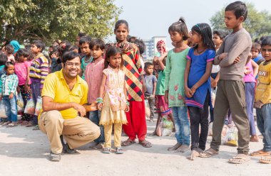 NOIDA, UTTAR PRADESH, INDIA - NOVEMBER 2020: Hindistan 'da Corona salgını sırasında gönüllülerin dağıttığı yiyecekleri toplamak için kenar mahalle veya köy bölgesinden gelen genç çocuklar veya öğrenciler. Topluma geri vermek..
