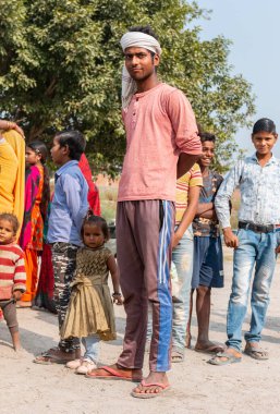 NOIDA, UTTAR PRADESH, INDIA - NOVEMBER 2020: Hindistan 'da Corona salgını sırasında gönüllülerin dağıttığı yiyecekleri toplamak için kenar mahalle veya köy bölgesinden gelen genç çocuklar veya öğrenciler. Topluma geri vermek..