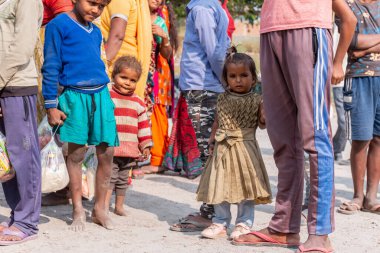 NOIDA, UTTAR PRADESH, INDIA - NOVEMBER 2020: Hindistan 'da Corona salgını sırasında gönüllülerin dağıttığı yiyecekleri toplamak için kenar mahalle veya köy bölgesinden gelen genç çocuklar veya öğrenciler. Topluma geri vermek..