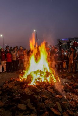 GHAZIABAD, UTTAR PRADESH, Hindistan - 2021 Hint çiftçiler Delhi-Up sınırındaki protesto sırasında Lohri festivalini şenlik ateşiyle kutluyorlar. Lohri festivali kutlaması kamp ateşiyle.