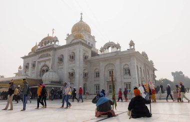 NEW DELHI, INDIA - JANUARY 2021: Gurdwara Bangla Sahib en önde gelen Sih gurdwara 'dır. Yeni Delhi 'nin en önemli eğlencelerinden biri. Gurdwara Bangla Sahib 'in önünde oturan Sikh hacılar.