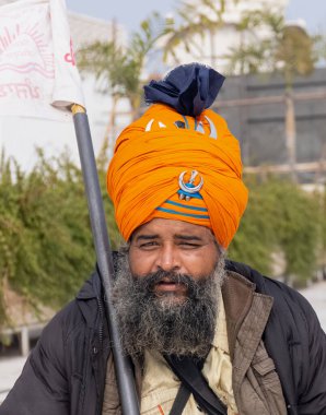 NEW DELHI, INDIA - HAZİRAN 2021: Gurdwara Bangla Sahib kompleksinin içinde oturan Sih adamın portresi. Gurdwara Bangla Sahib Sikh insanları için bir hacıdır..