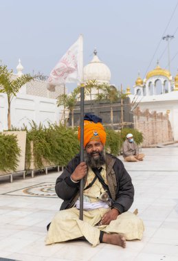 NEW DELHI, INDIA - HAZİRAN 2021: Gurdwara Bangla Sahib kompleksinin içinde oturan Sih adamın portresi. Gurdwara Bangla Sahib Sikh insanları için bir hacıdır..