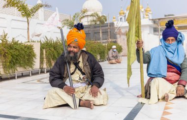 NEW DELHI, INDIA - HAZİRAN 2021: Gurdwara Bangla Sahib kompleksinin içinde oturan Sih adamın portresi. Gurdwara Bangla Sahib Sikh insanları için bir hacıdır..