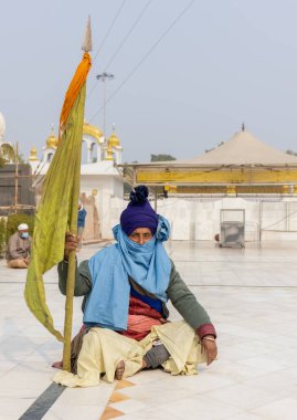 NEW DELHI, INDIA - HAZİRAN 2021: Gurdwara Bangla Sahib kompleksinin içinde oturan Sih adamın portresi. Gurdwara Bangla Sahib Sikh insanları için bir hacıdır..