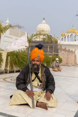 NEW DELHI, INDIA - HAZİRAN 2021: Gurdwara Bangla Sahib kompleksinin içinde oturan Sih adamın portresi. Gurdwara Bangla Sahib Sikh insanları için bir hacıdır..