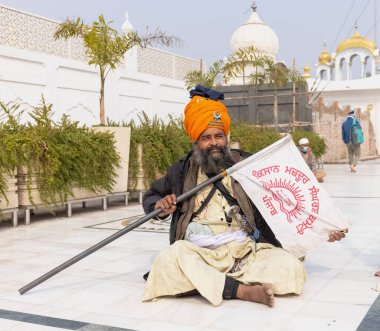 NEW DELHI, INDIA - HAZİRAN 2021: Gurdwara Bangla Sahib kompleksinin içinde oturan Sih adamın portresi. Gurdwara Bangla Sahib Sikh insanları için bir hacıdır..