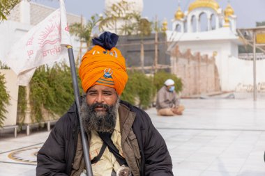 NEW DELHI, INDIA - HAZİRAN 2021: Gurdwara Bangla Sahib kompleksinin içinde oturan Sih adamın portresi. Gurdwara Bangla Sahib Sikh insanları için bir hacıdır..
