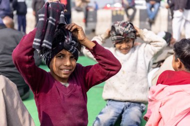 GHAZIABAD, UTTAR PRADESH, INDIA - HAZİKA 2021: Yüzünde tebessüm ve kafasında renkli susturucuyla genç bir çocuğun portresi.