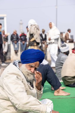 GHAZIABAD, UTTAR PRADESH, INDIA - HAZİKA 2021: Hintli Sih erkeğinin Gazipur sınırındaki çiftçi protestosuna katılan renkli türbanlı portresi.
