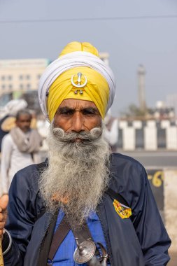 GHAZIABAD, UTTAR PRADESH, INDIA - HAZİKA 2021: Hintli Sih erkeğinin Gazipur sınırındaki çiftçi protestosuna katılan renkli türbanlı portresi.