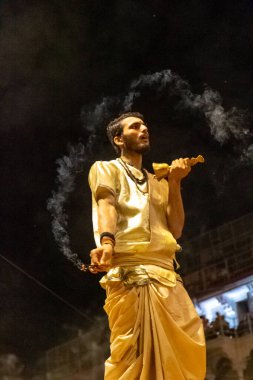 VARANASI, UTTAR PRADESH, INDIA - Nisan 2019: Varanasi şehrindeki Daswamedh ghat 'ta Maa Ganga aarti töreni yapan bir rahip.