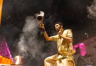 VARANASI, UTTAR PRADESH, INDIA - Nisan 2019: Varanasi şehrindeki Daswamedh ghat 'ta Maa Ganga aarti töreni yapan bir rahip.