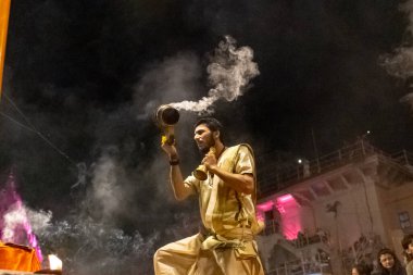VARANASI, UTTAR PRADESH, INDIA - Nisan 2019: Varanasi şehrindeki Daswamedh ghat 'ta Maa Ganga aarti töreni yapan bir rahip.
