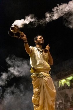 VARANASI, UTTAR PRADESH, INDIA - Nisan 2019: Varanasi şehrindeki Daswamedh ghat 'ta Maa Ganga aarti töreni yapan bir rahip.