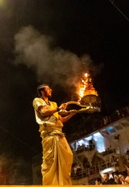 VARANASI, UTTAR PRADESH, INDIA - Nisan 2019: Varanasi şehrindeki Daswamedh ghat 'ta Maa Ganga aarti töreni yapan bir rahip.