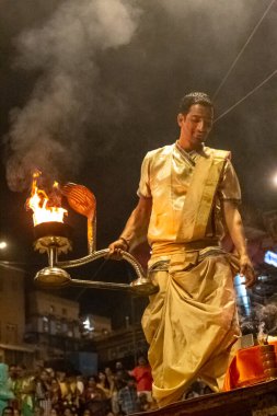 VARANASI, UTTAR PRADESH, INDIA - Nisan 2019: Varanasi şehrindeki Daswamedh ghat 'ta Maa Ganga aarti töreni yapan bir rahip.