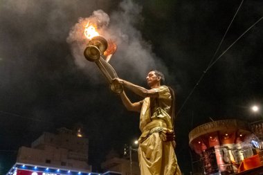 VARANASI, UTTAR PRADESH, INDIA - Nisan 2019: Varanasi şehrindeki Daswamedh ghat 'ta Maa Ganga aarti töreni yapan bir rahip.