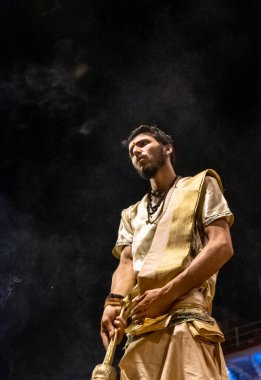 VARANASI, UTTAR PRADESH, INDIA - Nisan 2019: Varanasi şehrindeki Daswamedh ghat 'ta Maa Ganga aarti töreni yapan bir rahip.