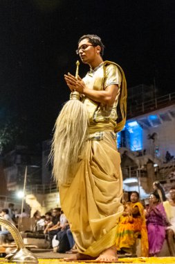 VARANASI, UTTAR PRADESH, INDIA - Nisan 2019: Varanasi şehrindeki Daswamedh ghat 'ta Maa Ganga aarti töreni yapan bir rahip.