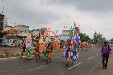 GHAZIABAD, UTTAR PRADESH, INDIA - Temmuz 2019: Kanwar 'ı omuzlarında taşıyan bir Hindu müridi, her yıl sokaklarda çıplak ayakla kutsal Ganga suyuyla kanwar yatını icra ediyor..