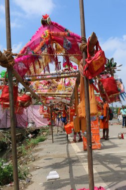 GHAZIABAD, UTTAR PRADESH, INDIA - Temmuz 2019: Kanwar 'ı omuzlarında taşıyan bir Hindu müridi, her yıl sokaklarda çıplak ayakla kutsal Ganga suyuyla kanwar yatını icra ediyor..
