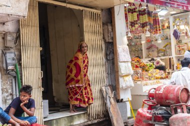VRINDAVAN, UTTAR PRADESH, INDIA - AĞUSTOS 2021: Krishna Janmashtami, Krishna Janmashtami 'yi kutlamak için Vrindavan sokaklarında geleneksel sari ile yürüyen Hintli kadın portresi.
