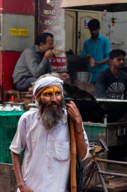 VRINDAVAN, UTTAR PRADESH, INDIA - AĞUSTOS 2021: Krishna Janmashtami, Hintli yaşlı adamın (Sadhu) portresi Krishna Janmashtami 'nin kutlaması için Vrindavan sokaklarında yürüyor.
