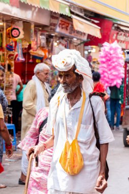 VRINDAVAN, UTTAR PRADESH, INDIA - AĞUSTOS 2021: Krishna Janmashtami, Hintli yaşlı adamın (Sadhu) portresi Krishna Janmashtami 'nin kutlaması için Vrindavan sokaklarında yürüyor.