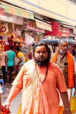 VRINDAVAN, UTTAR PRADESH, INDIA - AĞUSTOS 2021: Krishna Janmashtami, Hintli yaşlı adamın (Sadhu) portresi Krishna Janmashtami 'nin kutlaması için Vrindavan sokaklarında yürüyor.