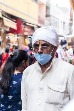 VRINDAVAN, UTTAR PRADESH, INDIA - AĞUSTOS 2021: Krishna Janmashtami, Krishna Janmashtami kutlamaları için Vrindavan sokaklarında yürüyen Hintli bir adamın portresi.