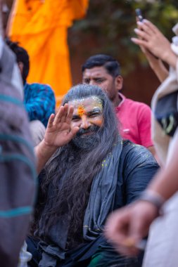 Varanasi, Uttar Pradesh, Hindistan - 21 Mart 2024: Masan Holi, manikarnika ghat kutlamaları sırasında yüzü organik renklerle boyanmış kimliği belirsiz bir grup dindar.