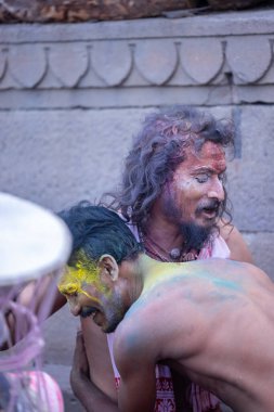 Varanasi, Uttar Pradesh, Hindistan - 21 Mart 2024: Masan Holi, manikarnika ghat kutlamaları sırasında yüzü organik renklerle boyanmış kimliği belirsiz bir grup dindar.