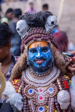 Varanasi, Uttar Pradesh, Hindistan - 21 Mart 2024: Masan Holi, Mandarika Ghat 'ta düzenlenen bayram sırasında efendi shiva gibi giyinmiş kuru külle boyanmış bir erkek müridin portresi.