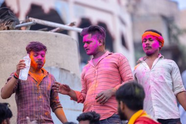 Varanasi, Uttar Pradesh, Hindistan - 21 Mart 2024: Masan Holi, manikarnika ghat kutlamaları sırasında yüzü organik renklerle boyanmış kimliği belirsiz bir grup dindar.