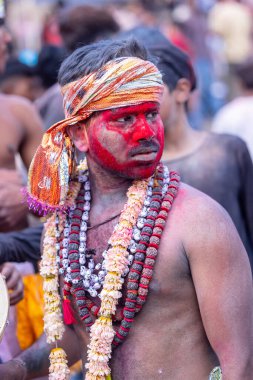 Varanasi, Uttar Pradesh, Hindistan - 21 Mart 2024: Masan Holi, manikarnika ghat kutlamaları sırasında yüzü organik renklerle boyanmış kimliği belirsiz bir müridin portresi.